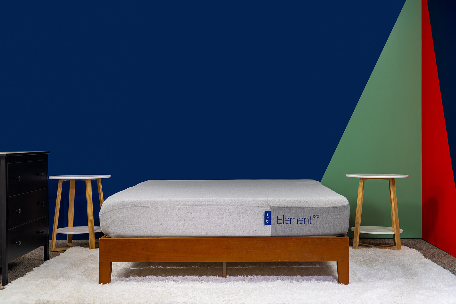 Distant photo of the Casper Element Pro Mattress on a bedframe in a bedroom taken from a front angle.