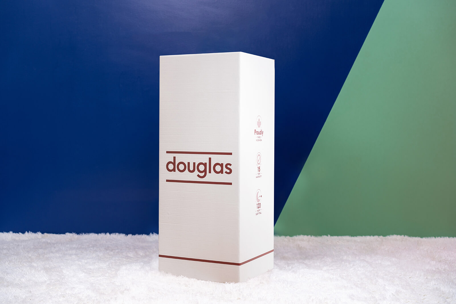 Photo of the Douglas Original Mattress box on the floor in a bedroom taken from a front angle.