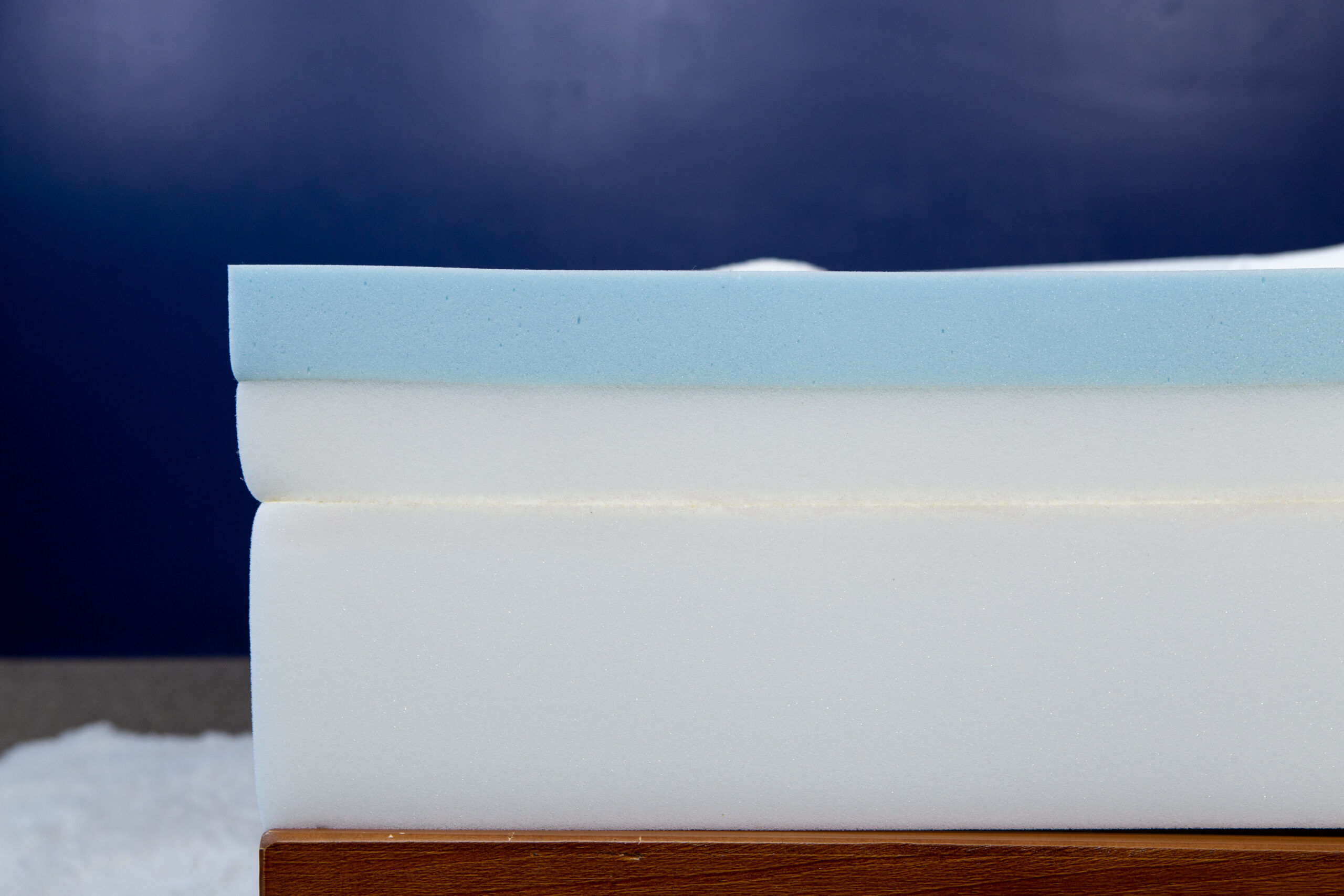 Image of the Douglas Original mattress layers on a bedframe without the cover and shot from a side angle.