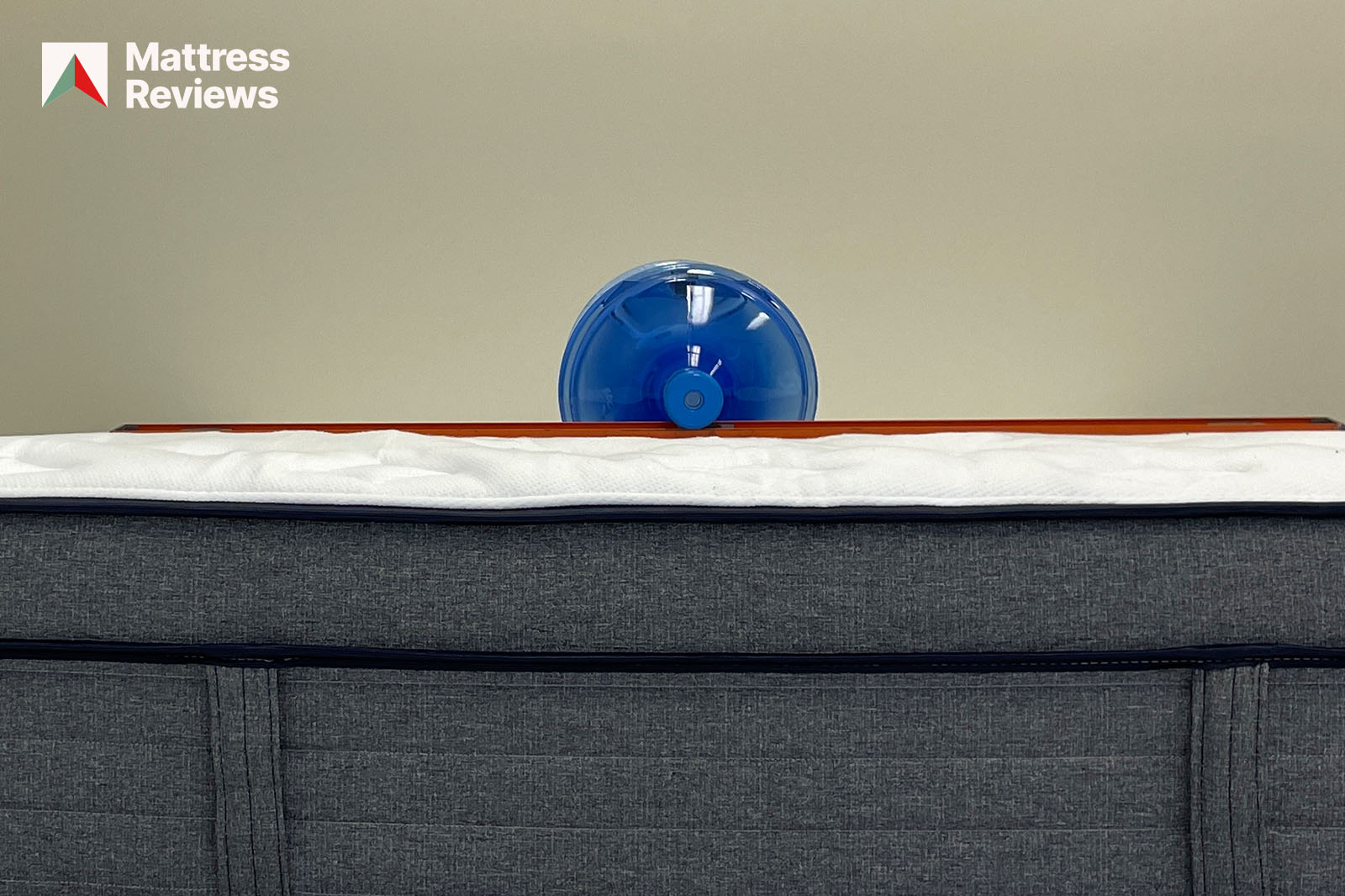Photo of a water jug and level sitting on top of the Endy Hybrid mattress to demonstrate firmness