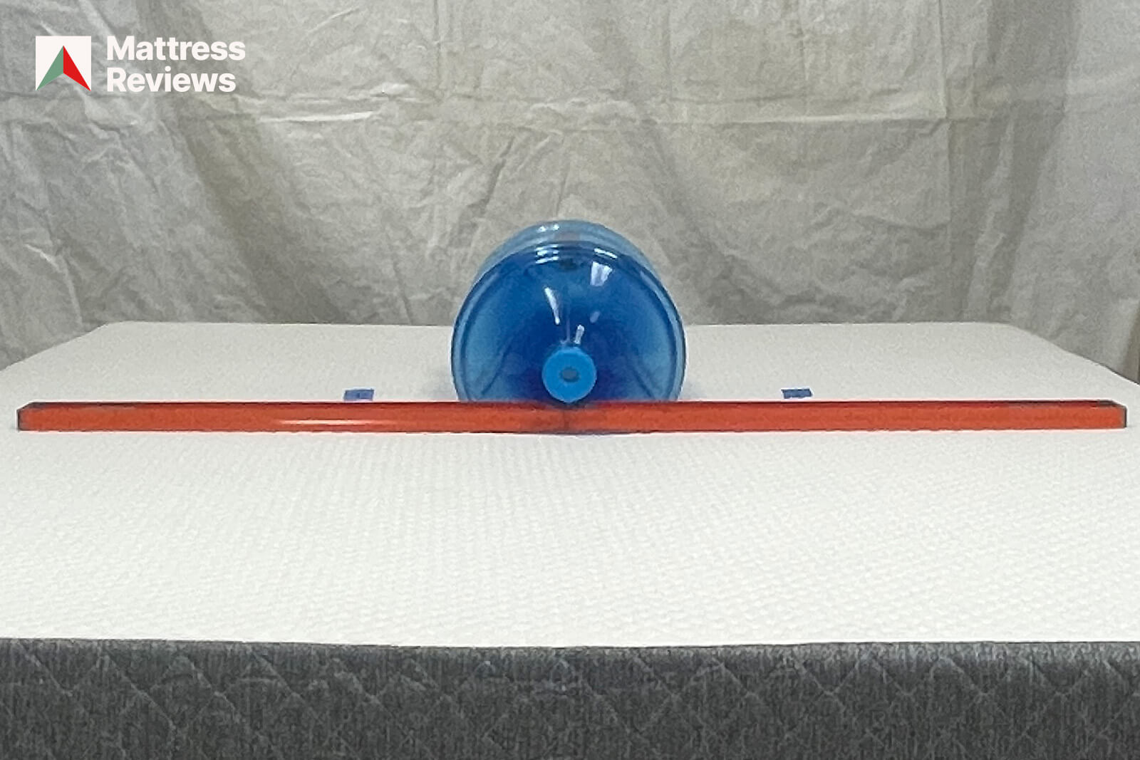 Photo of a water jug and level on the GhostBed Classic mattress to demonstrate firmness