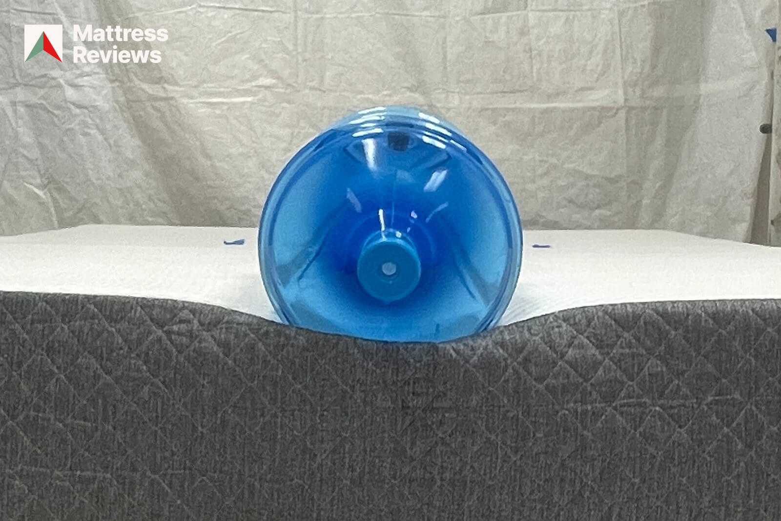 photo of a water bottle lying on the edge of a GhostBed Classic mattress to demonstrate edge support