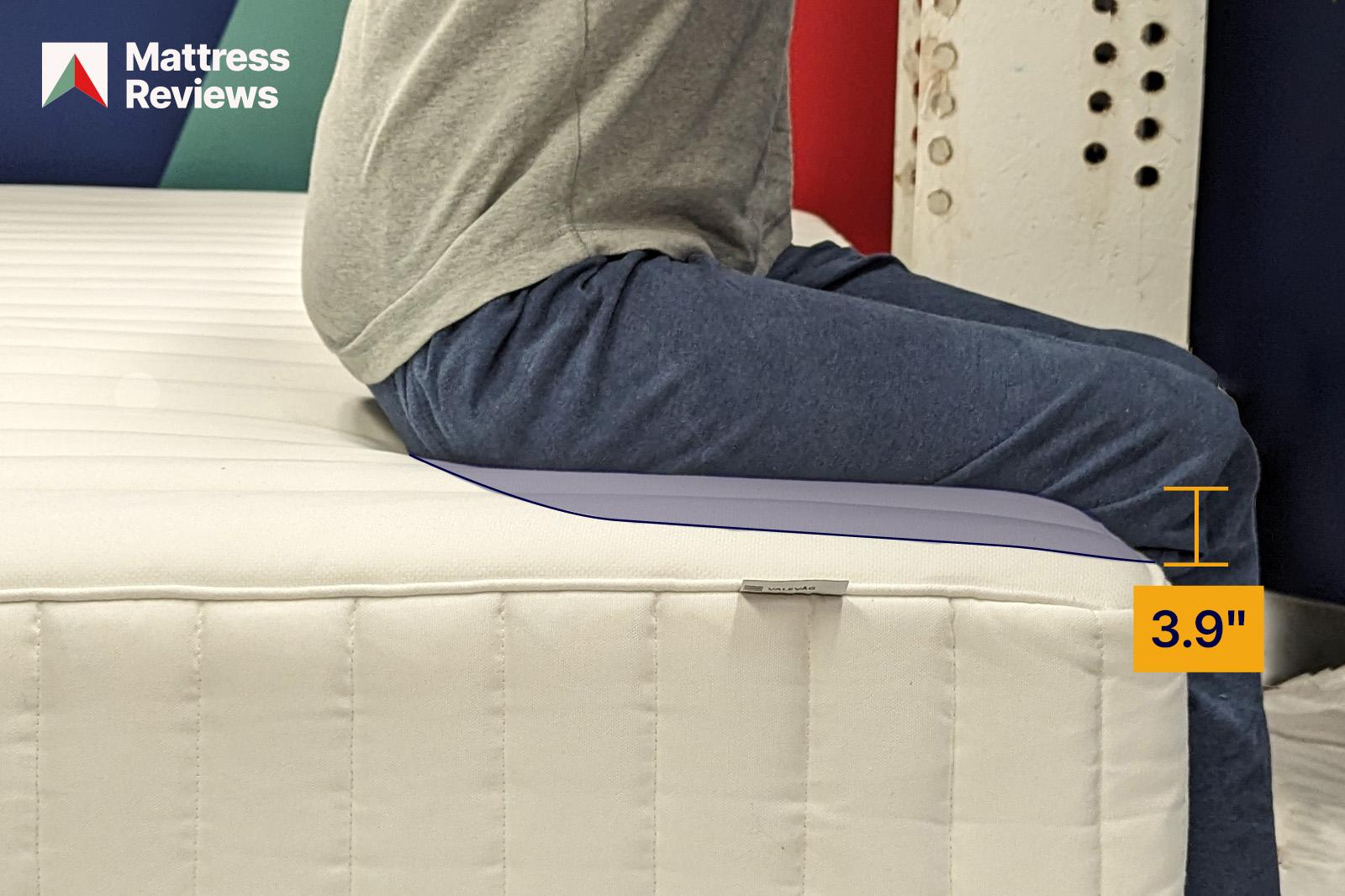 photo of a mannequin sitting on the edge of the IKEA Valevag mattress, showing a displacement of 3.9