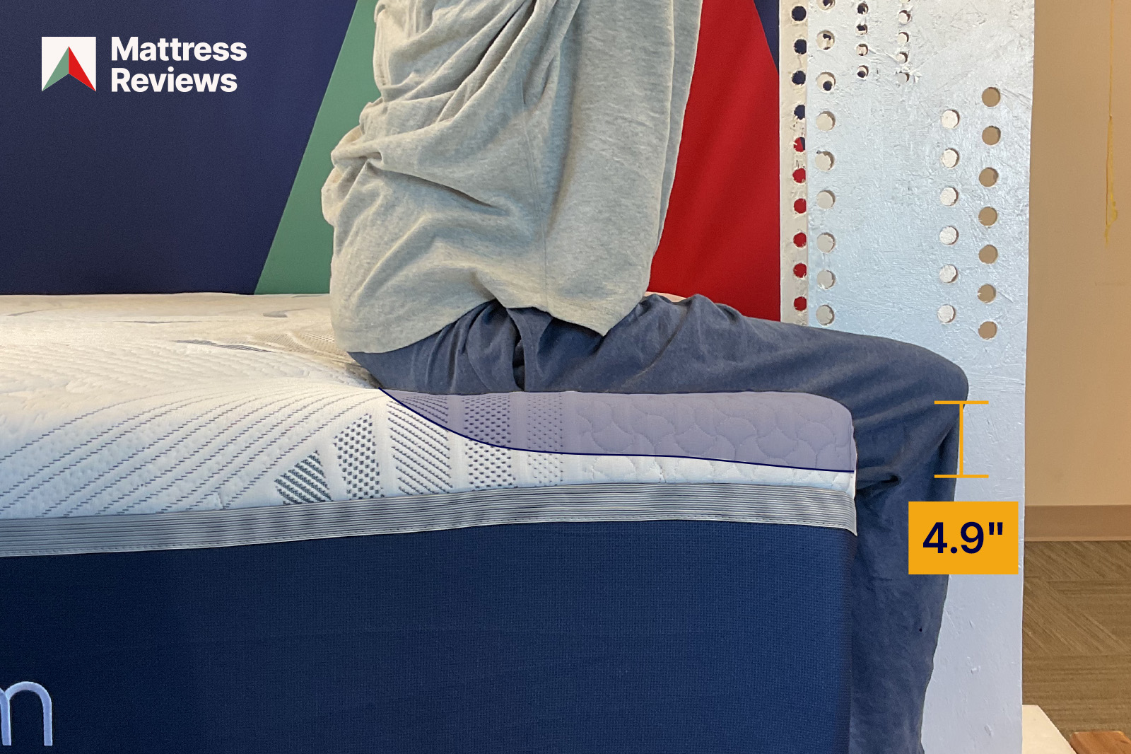 photo of a mannequin sitting on the edge of the novaform mattress with 49