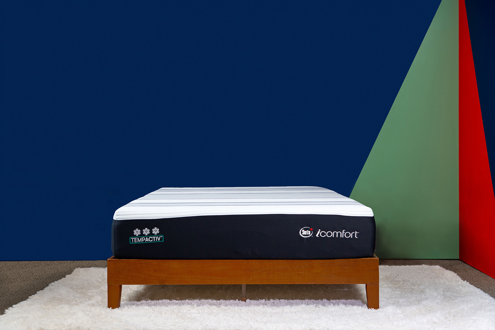 Distant photo of the Serta iComfort TempActiv I Mattress on a bedframe in a bedroom taken from a front angle.
